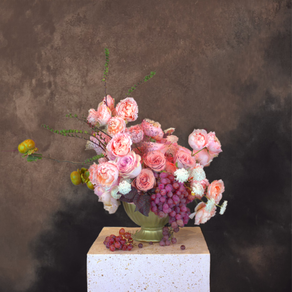 Pink floral arrangement with dark grapes, inspired by classic still-life, ideal for elegant settings.