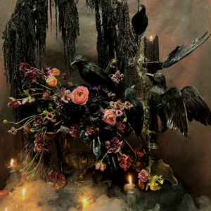 Gothic Halloween floral arrangement with dark blooms, a black raven, and antique-style urn for party decor in Los Angeles.